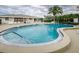 Community pool with sun loungers surrounded by tropical foliage at 8210 Aquila St # 218, Port Richey, FL 34668