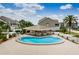 Inviting community pool with tables, chairs, and a cabana, surrounded by lush landscaping and well-maintained buildings at 8210 Aquila St # 218, Port Richey, FL 34668
