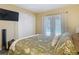 Bright bedroom with sliding doors to a patio, featuring cozy bedding and a modern ceiling fan at 8600 N Briar Patch Dr, Port Richey, FL 34668