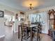 Cozy dining room with a wooden table, four chairs, and a decorative light fixture, adjacent to the kitchen at 8600 N Briar Patch Dr, Port Richey, FL 34668
