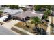 A well-kept single-story home with an attached garage, a front porch, and a lush palm tree in the yard at 8600 N Briar Patch Dr, Port Richey, FL 34668