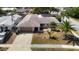Aerial view of a well-maintained house with a lush lawn, and an attached garage, near a street intersection at 8600 N Briar Patch Dr, Port Richey, FL 34668