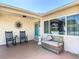 Inviting front porch with comfortable seating and a decorative sunburst wall hanging, perfect for relaxing at 8600 N Briar Patch Dr, Port Richey, FL 34668