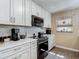 Kitchen boasts white cabinets, tile backsplash, and modern appliances for the home cook at 8600 N Briar Patch Dr, Port Richey, FL 34668