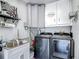 Well-equipped laundry room with modern washer and dryer set, cabinets and utility sink at 8600 N Briar Patch Dr, Port Richey, FL 34668