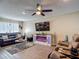 Comfortable living room with a ceiling fan, entertainment center, and a modern fireplace feature at 8600 N Briar Patch Dr, Port Richey, FL 34668
