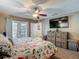 Spacious main bedroom with a ceiling fan, French doors, and wood-look flooring, stylish and comfortable at 8600 N Briar Patch Dr, Port Richey, FL 34668