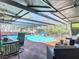 Relaxing pool area with covered patio, table, and outdoor furniture at 8600 N Briar Patch Dr, Port Richey, FL 34668