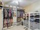 Spacious walk-in closet with custom shelving, hanging rods, drawers, and a ceiling fan for ventilation at 8600 N Briar Patch Dr, Port Richey, FL 34668