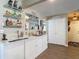 Beautiful wet bar with shelving, white cabinets, and view of the pantry at 8600 N Briar Patch Dr, Port Richey, FL 34668