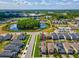Aerial view of home in community, showing location near pond, pool, and surrounding neighborhood at 8630 Campus Woods Way, New Port Richey, FL 34655