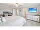 Comfortable bedroom with a striped bedspread, a mounted tv, and plenty of natural light at 8630 Campus Woods Way, New Port Richey, FL 34655
