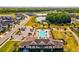 Aerial shot of a community pool, playground, and pond surrounded by beautiful landscaping and residential homes at 8630 Campus Woods Way, New Port Richey, FL 34655