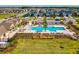 Aerial view of a large community pool featuring ample seating, landscaping, and nearby amenities at 8630 Campus Woods Way, New Port Richey, FL 34655