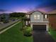 Charming two-story home featuring a well-manicured lawn and a paved driveway leading to a two-car garage at 8630 Campus Woods Way, New Port Richey, FL 34655