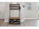 Foyer area featuring a coat rack with shoe storage, neutral walls, and stylish gray wood-look tile flooring at 8630 Campus Woods Way, New Port Richey, FL 34655