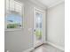 Bright foyer featuring a decorative glass door, a window with blinds, and stylish gray wood-look tile flooring at 8630 Campus Woods Way, New Port Richey, FL 34655