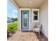 Inviting front porch with a decorative glass door, window, and chair for relaxing, complete with brick pavers at 8630 Campus Woods Way, New Port Richey, FL 34655