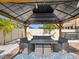 Relaxing gazebo featuring comfortable seating, a dining area, and stylish lighting for outdoor enjoyment at 8630 Campus Woods Way, New Port Richey, FL 34655