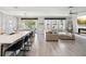 Open-concept living area featuring a modern kitchen island, dining space, living room, fireplace, and gray wood-look tile floors at 8630 Campus Woods Way, New Port Richey, FL 34655