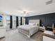 Spacious main bedroom featuring a tufted headboard, large windows, and a dark accent wall at 8630 Campus Woods Way, New Port Richey, FL 34655