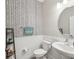 Stylish powder room featuring black and white patterned wallpaper, a pedestal sink, and modern fixtures at 8630 Campus Woods Way, New Port Richey, FL 34655
