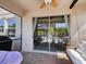 Screened-in patio featuring comfortable furniture and view of the outdoor living area through large glass doors at 8630 Campus Woods Way, New Port Richey, FL 34655