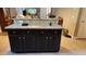 A kitchen island with dark cabinets and granite countertop with room for seating at 9007 49Th E Ave, Palmetto, FL 34221