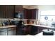 A modern kitchen is equipped with dark wood cabinets, a microwave, and stainless steel appliances at 9007 49Th E Ave, Palmetto, FL 34221