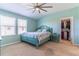 Bedroom in light blue with walk-in closet, ceiling fan, and plush carpeting at 9103 Carolina Wren Dr, Tampa, FL 33626