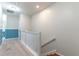 Upstairs hallway with white railing, neutral carpet, and blue accent wall at 9103 Carolina Wren Dr, Tampa, FL 33626