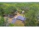 The aerial view showcases a home nestled among lush trees with a long driveway and storage sheds at 9226 Dan Lynn St, Brooksville, FL 34601