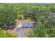 An aerial perspective reveals the home's setting among mature trees and long driveway on a sunny day at 9226 Dan Lynn St, Brooksville, FL 34601