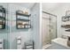 The renovated bathroom with a modern glass-enclosed shower and shelving unit at 9226 Dan Lynn St, Brooksville, FL 34601