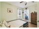 A bedroom with light-green walls and a closet with a full wardrobe and lots of clothing at 9226 Dan Lynn St, Brooksville, FL 34601