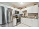 Modern kitchen with stainless steel appliances, granite countertops, and white cabinetry at 9226 Dan Lynn St, Brooksville, FL 34601