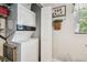 Practical laundry area features stacked washer and dryer with overhead shelving at 9226 Dan Lynn St, Brooksville, FL 34601