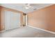 Carpeted bedroom with closet, window, ceiling fan, and neutral wall color at 9434 Hayward Rd, Spring Hill, FL 34608