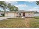 Charming single-story home with a well-manicured lawn and a inviting red front door at 9434 Hayward Rd, Spring Hill, FL 34608