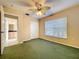 Bedroom featuring green carpet, a ceiling fan and natural lighting from a large window at 1006 Sweet Jasmine Dr, Trinity, FL 34655