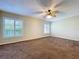 Bright carpeted bedroom with natural light from the shuttered windows and neutral color walls at 1006 Sweet Jasmine Dr, Trinity, FL 34655