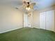 Cozy bedroom featuring a ceiling fan, neutral walls, and closet with paneled doors at 1006 Sweet Jasmine Dr, Trinity, FL 34655