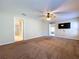 A spacious carpeted bedroom equipped with ceiling fan, and an entertainment center at 1006 Sweet Jasmine Dr, Trinity, FL 34655