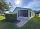 Home exterior featuring a screened porch and well-maintained landscaping at 1006 Sweet Jasmine Dr, Trinity, FL 34655
