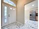 Spacious foyer featuring elegant tile flooring, a view into the kitchen, and a bright white front door at 1006 Sweet Jasmine Dr, Trinity, FL 34655