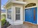 Inviting home entrance with a bright blue front door, detailed trim, and large windows for natural light at 1006 Sweet Jasmine Dr, Trinity, FL 34655