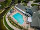 Aerial view of a pool with a spa, lounge chairs, and a covered patio at 1006 Sweet Jasmine Dr, Trinity, FL 34655