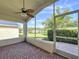 Relaxing screened porch with a lake view, brick pavers, and a ceiling fan at 1006 Sweet Jasmine Dr, Trinity, FL 34655