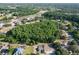 Aerial view of neighborhood showing wooded areas, homes with pools, and roadways on a sunny day at 10228 Beechcraft St, New Port Richey, FL 34654