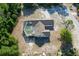 Aerial view of a house with a screened pool, driveway, and treed landscaping on a spacious lot at 10228 Beechcraft St, New Port Richey, FL 34654